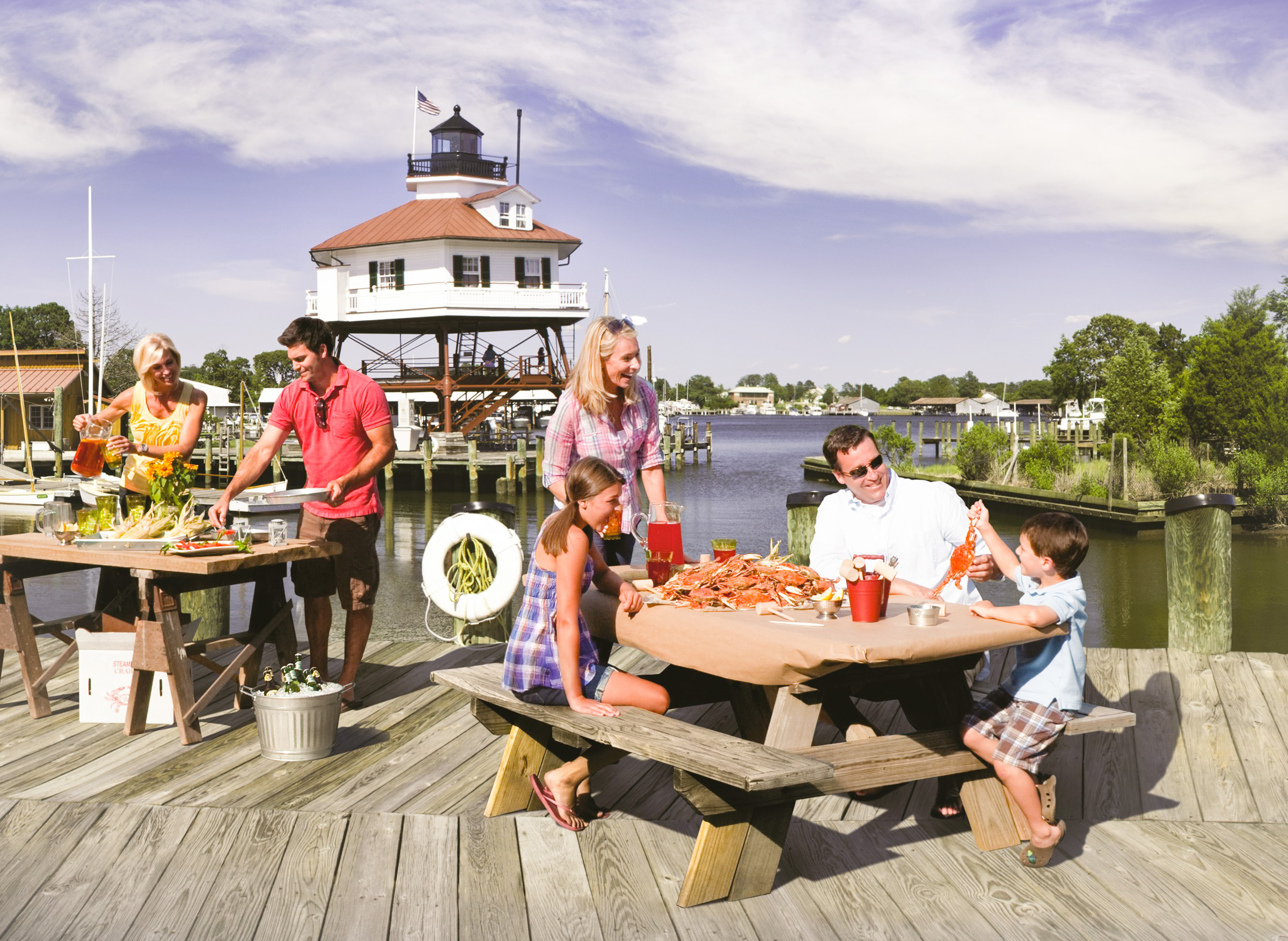 People at picnic tables covered with brown paper and steamed crabs in Solomons Island, Maryland, USA